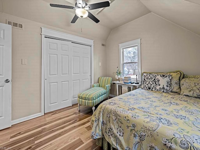 bedroom with vaulted ceiling, light hardwood / wood-style flooring, a closet, and ceiling fan