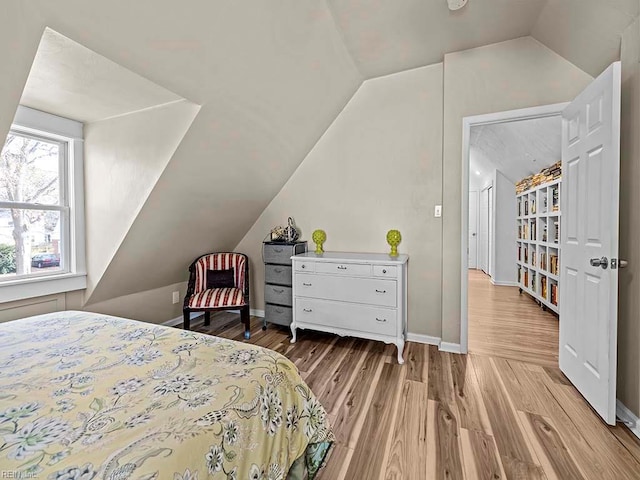 bedroom with light wood-type flooring and lofted ceiling