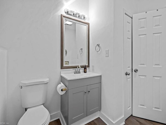 bathroom with hardwood / wood-style flooring, vanity, and toilet