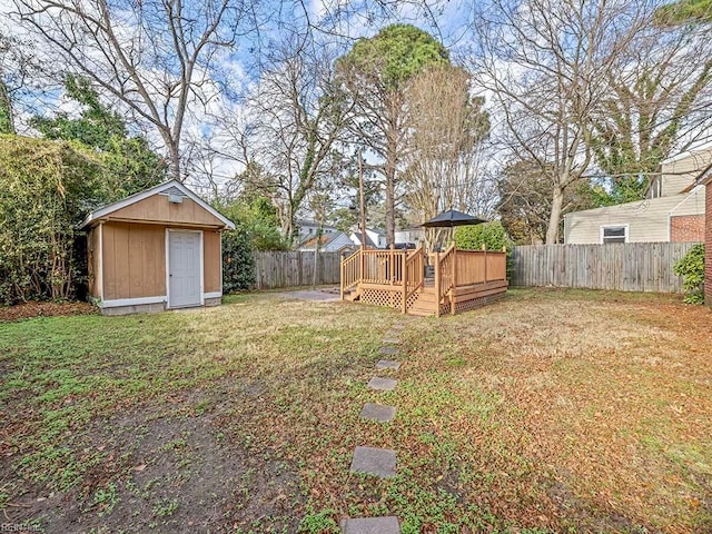 view of yard featuring a storage unit and a wooden deck