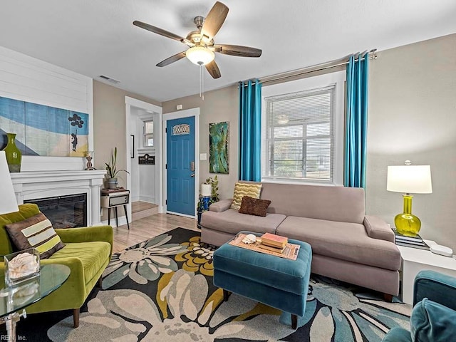 living room with ceiling fan and light hardwood / wood-style flooring