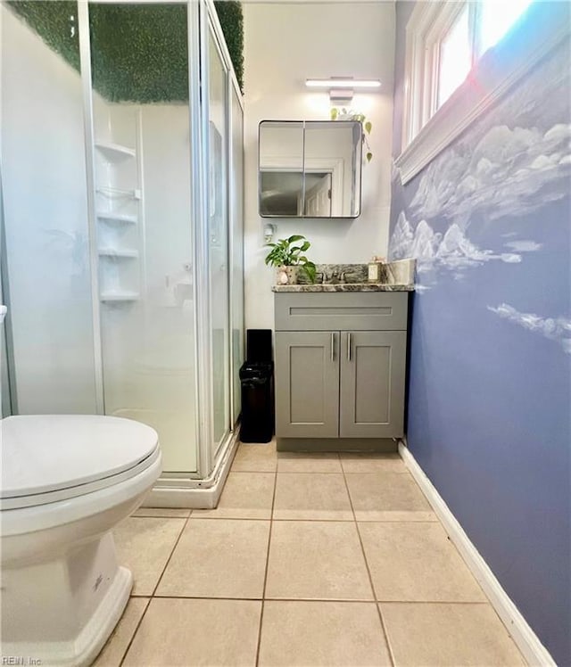 bathroom featuring toilet, vanity, tile patterned floors, and an enclosed shower