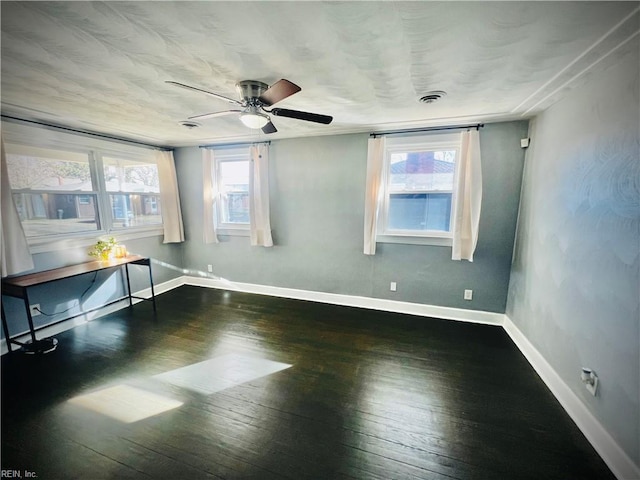 unfurnished room with dark hardwood / wood-style floors, plenty of natural light, and ceiling fan