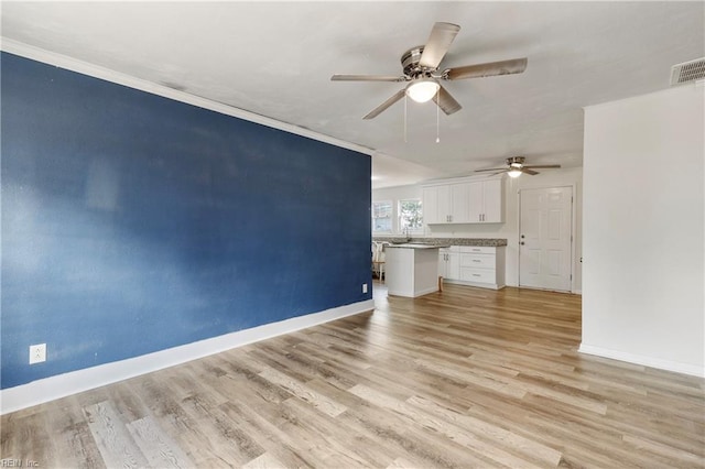 unfurnished living room featuring ceiling fan, light hardwood / wood-style flooring, and ornamental molding