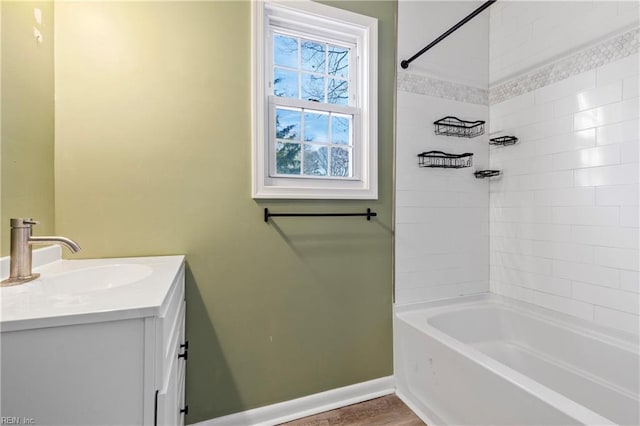 bathroom featuring hardwood / wood-style flooring, vanity, and tiled shower / bath combo