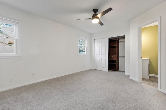 unfurnished bedroom featuring multiple windows, ceiling fan, a closet, and light carpet