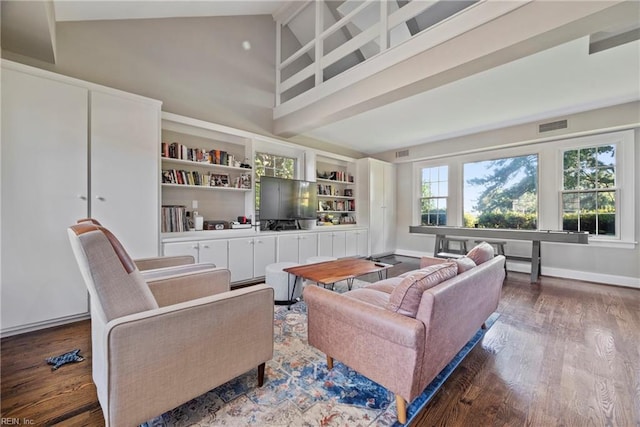 living room with hardwood / wood-style floors, high vaulted ceiling, and built in features