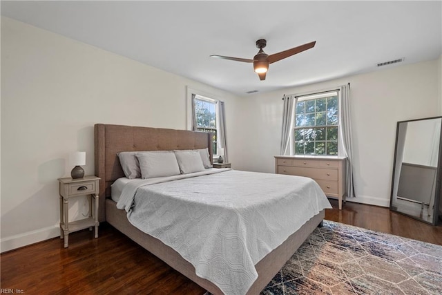 bedroom featuring multiple windows, ceiling fan, and dark hardwood / wood-style flooring