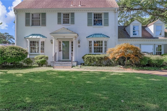 colonial house featuring a front lawn