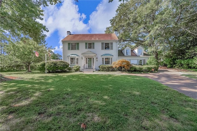 colonial-style house with a front lawn