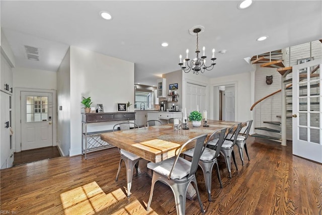 dining space featuring sink, dark hardwood / wood-style flooring, and an inviting chandelier