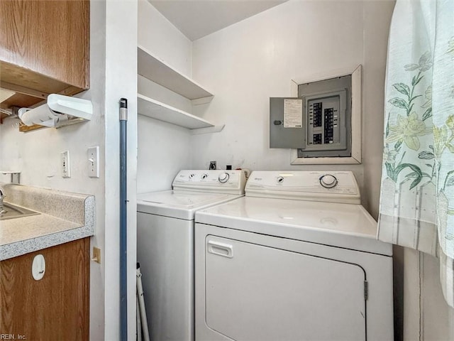 clothes washing area featuring electric panel and separate washer and dryer