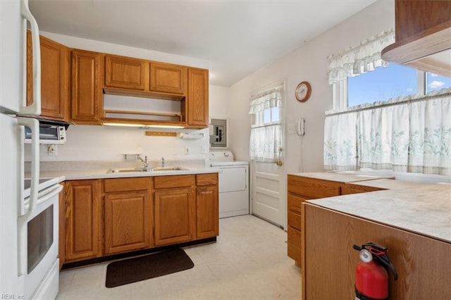 kitchen featuring washer / clothes dryer, sink, white fridge, and stove