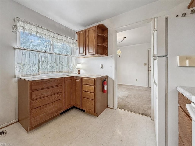 kitchen with white fridge and light carpet