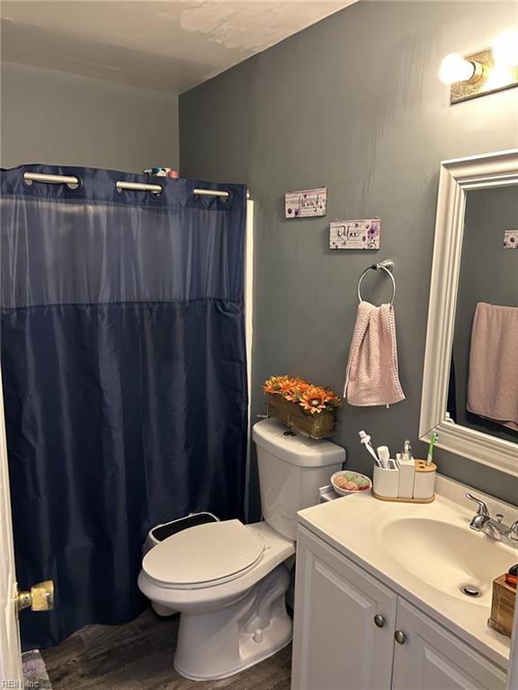 bathroom with a shower with curtain, toilet, vanity, and hardwood / wood-style flooring