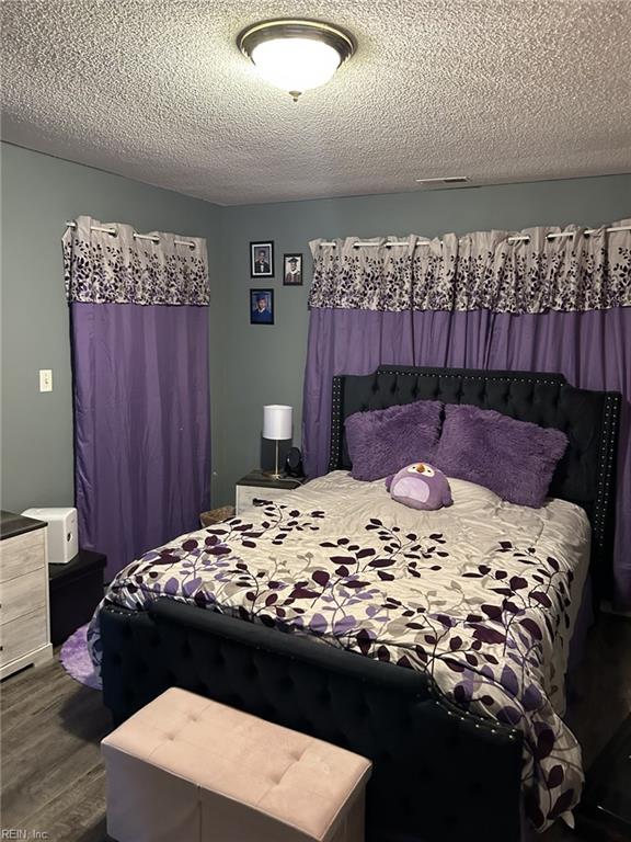 bedroom with wood-type flooring and a textured ceiling