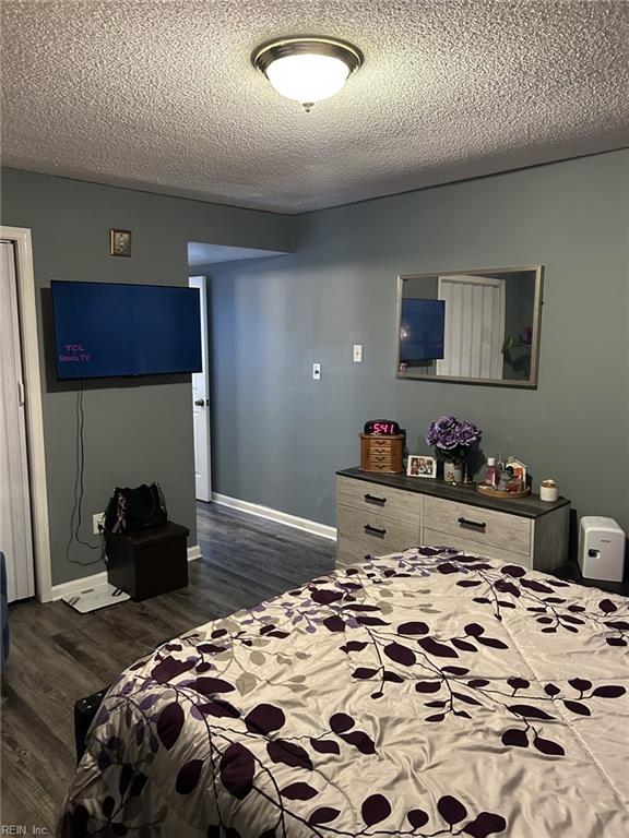 bedroom featuring a textured ceiling and dark wood-type flooring