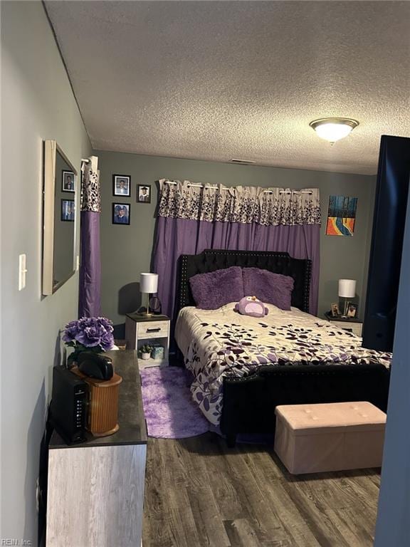 bedroom featuring dark hardwood / wood-style floors and a textured ceiling