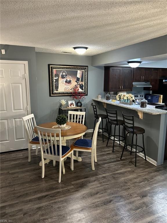 dining area featuring a textured ceiling and dark wood-type flooring