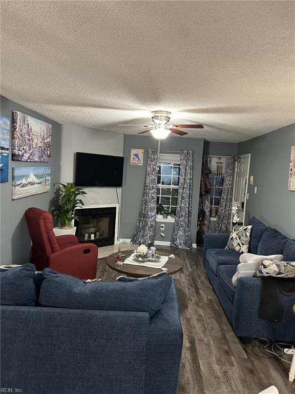 living room with ceiling fan, dark hardwood / wood-style flooring, and a textured ceiling