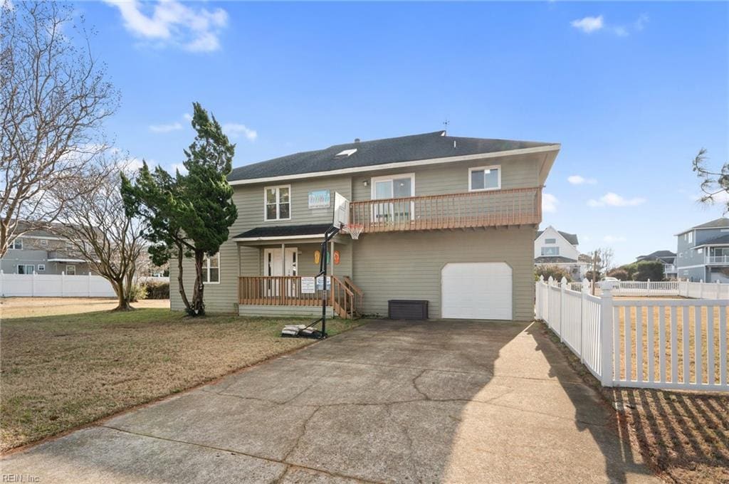 view of front of property featuring a front yard, a porch, a balcony, and a garage