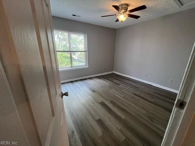 unfurnished room with a textured ceiling, ceiling fan, and dark wood-type flooring