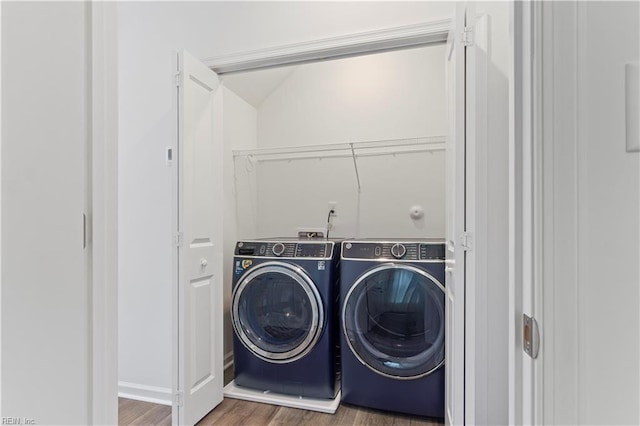 clothes washing area with washing machine and dryer and dark hardwood / wood-style floors