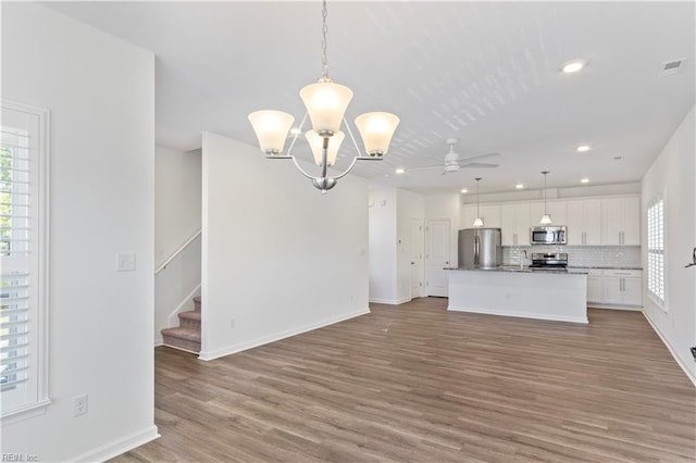 interior space with ceiling fan with notable chandelier, light hardwood / wood-style floors, and sink