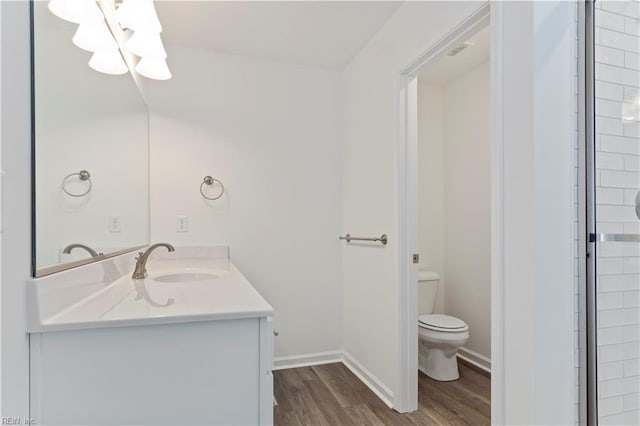 bathroom with hardwood / wood-style floors, vanity, and toilet