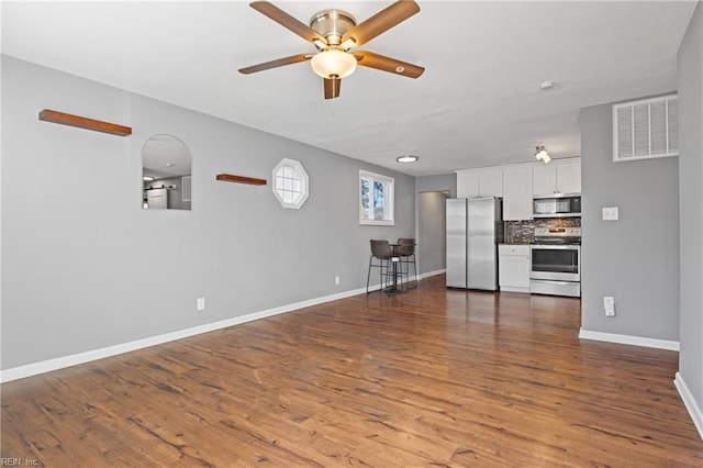 unfurnished living room with ceiling fan and hardwood / wood-style flooring