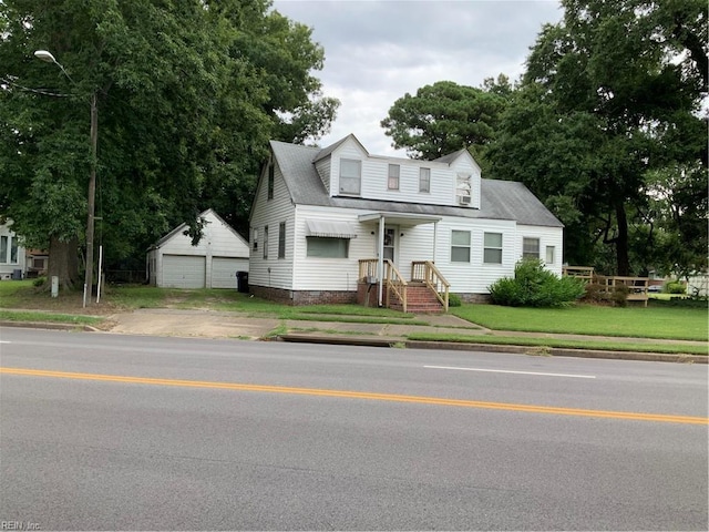 view of front facade featuring an outbuilding, a garage, and a front yard