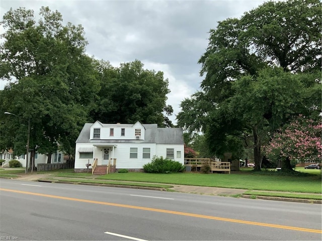 new england style home featuring a front yard