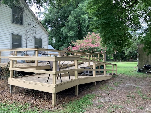 wooden terrace featuring a lawn