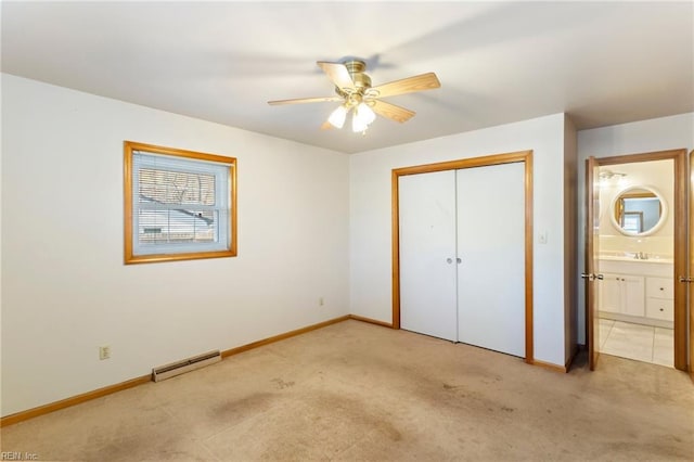 unfurnished bedroom with ceiling fan, ensuite bath, light carpet, and a closet