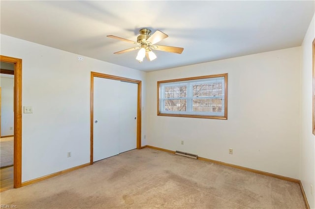 unfurnished bedroom with ceiling fan, light colored carpet, and a closet