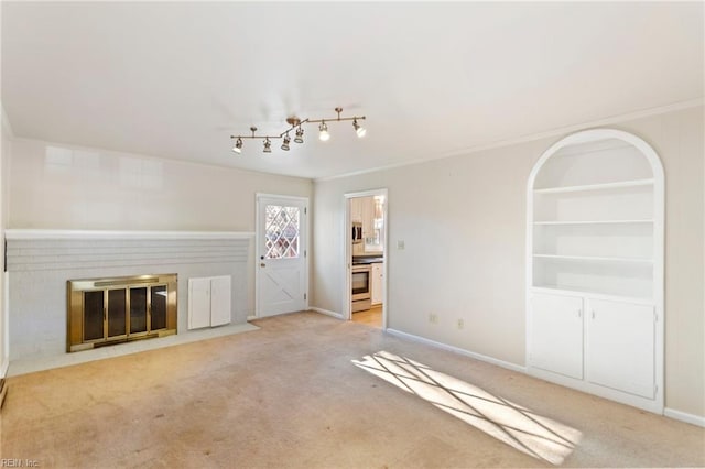 unfurnished living room featuring a fireplace, ornamental molding, and light carpet