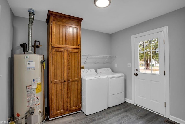 washroom with cabinets, washer and dryer, gas water heater, and hardwood / wood-style floors