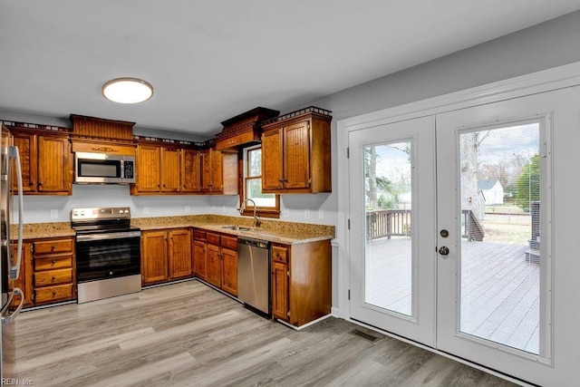 kitchen with french doors, stainless steel appliances, and light wood-type flooring