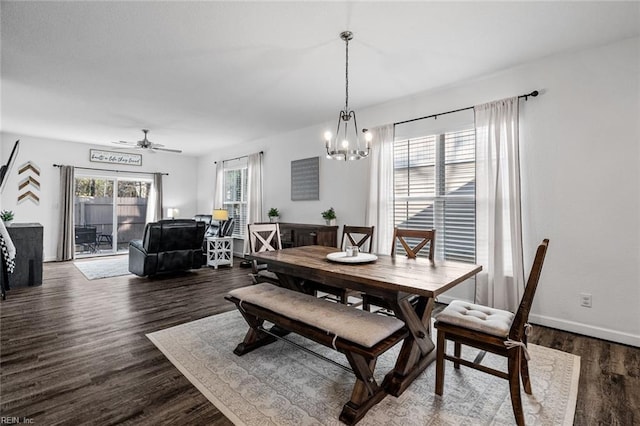 dining space featuring ceiling fan with notable chandelier and dark wood-type flooring