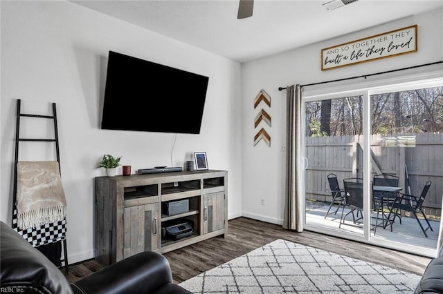 living room featuring ceiling fan and dark wood-type flooring