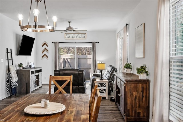 dining space with ceiling fan with notable chandelier and dark hardwood / wood-style floors