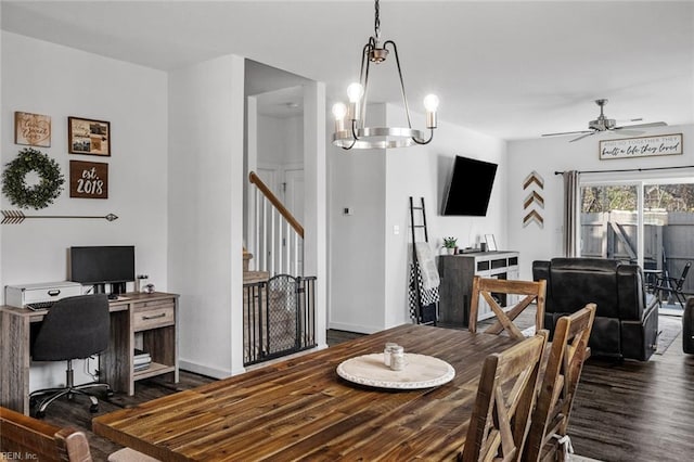 dining area with dark wood-type flooring and ceiling fan with notable chandelier