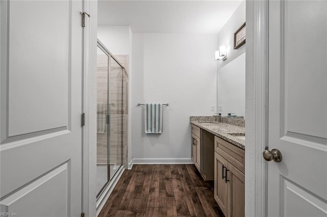 bathroom with vanity, a shower with shower door, and wood-type flooring