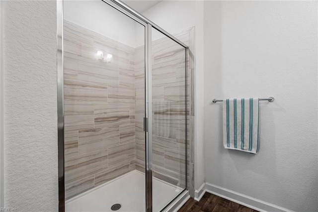 bathroom featuring hardwood / wood-style floors and a shower with door