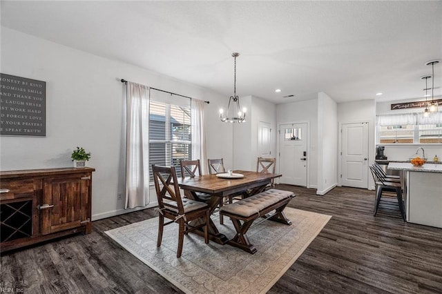 dining room with dark wood-type flooring and an inviting chandelier