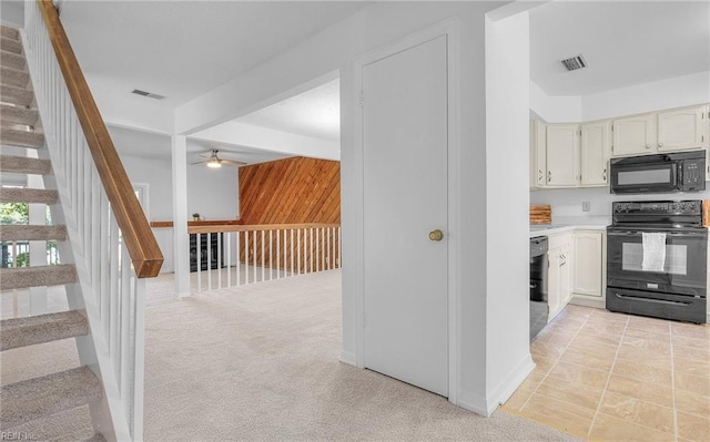 kitchen with light colored carpet, white cabinetry, ceiling fan, and black appliances