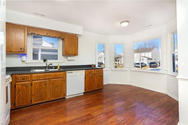 kitchen with white appliances, dark wood-type flooring, and sink