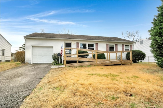 ranch-style house featuring a deck, a front yard, and a garage