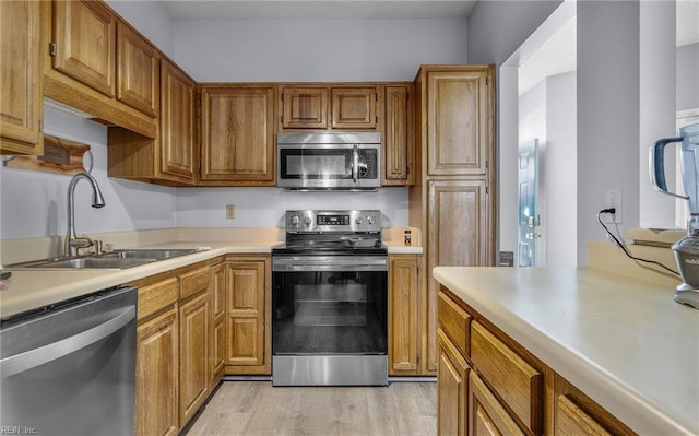 kitchen with light wood-type flooring, sink, and appliances with stainless steel finishes