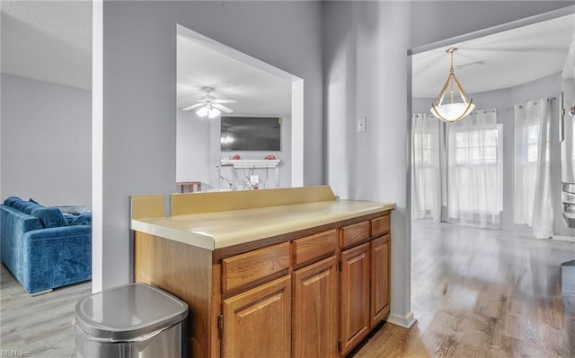 kitchen with decorative light fixtures, a textured ceiling, light hardwood / wood-style floors, and ceiling fan